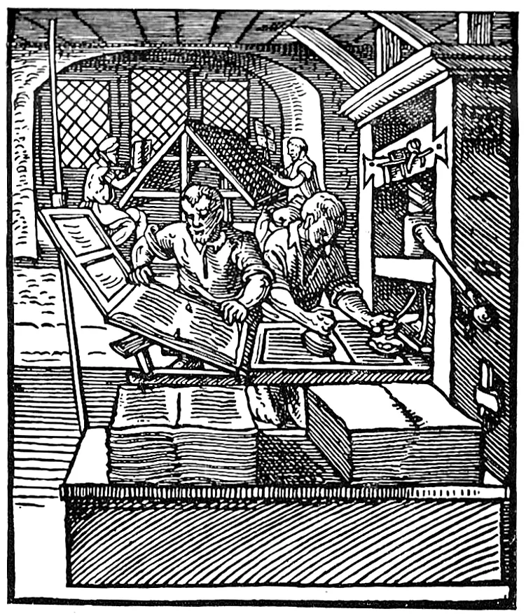 A sixteenth century woodcut of a printing shop: a bearded pressman lays a sheet on the tympan of a wooden press while a second man inks the type with leather balls, a compositor works at a type case behind them, and printed sheets are stacked in front.