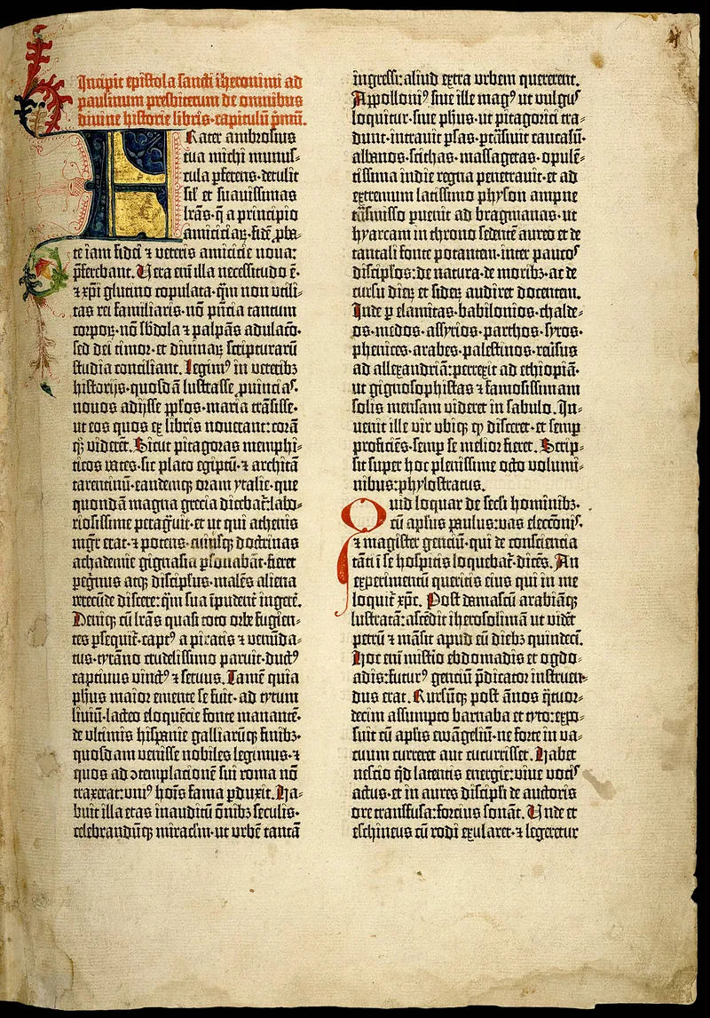 A page from the Gutenberg Bible: two columns of black letter type on vellum under a red rubric, with a large blue and gold illuminated initial and an inked vine border running down the left margin.